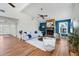 Cozy living room featuring a stone fireplace, wood floors, neutral furnishings, and abundant natural light at 4406 17Th W St, Palmetto, FL 34221