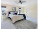 Bright main bedroom featuring neutral paint, carpet, a ceiling fan, and two windows at 4406 17Th W St, Palmetto, FL 34221
