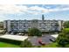 Low angle view of a white apartment complex with balconies, palm trees, parking and blue sky with clouds at 4440 Ironwood Cir # 509D, Bradenton, FL 34209