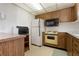 Efficient kitchen featuring wood cabinetry, a compact layout, and essential appliances at 4440 Ironwood Cir # 509D, Bradenton, FL 34209
