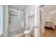 Bright bathroom with a walk-in shower, integrated storage, toilet and doorway view into the bedroom at 446 Burns Ct, Sarasota, FL 34236