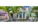 Charming home featuring arched windows and a quaint patio, framed by lush palm trees for a tropical feel at 446 Burns Ct, Sarasota, FL 34236