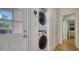 Laundry area featuring a stacked washer and dryer unit adjacent to a door with a glass window at 446 Burns Ct, Sarasota, FL 34236