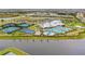 A vibrant community center featuring swimming pools, sports courts, and recreational areas against a lakeside backdrop at 4820 Coastal Days Ln, Bradenton, FL 34211