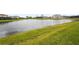 Tranquil backyard featuring a scenic lake view surrounded by lush greenery and neighboring homes at 4820 Coastal Days Ln, Bradenton, FL 34211