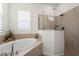 Luxurious bathroom featuring a soaking tub and a glass-enclosed shower with elegant tile work at 4820 Coastal Days Ln, Bradenton, FL 34211