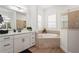 Serene bathroom with a soaking tub, separate glass shower, and white cabinets at 4820 Coastal Days Ln, Bradenton, FL 34211
