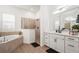 Bright and modern bathroom with dual sinks, a soaking tub, and a glass walk-in shower at 4820 Coastal Days Ln, Bradenton, FL 34211