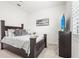 Bedroom with a dark wood frame bed, stylish decor, and a TV with a beach scene at 4820 Coastal Days Ln, Bradenton, FL 34211