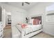 Comfortable bedroom features a bed with decorative pillows, a bench, and a closet for ample storage at 4820 Coastal Days Ln, Bradenton, FL 34211