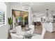 Dining area with glass table, white chairs, and sliding doors to an outdoor living space at 4820 Coastal Days Ln, Bradenton, FL 34211