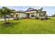 Charming single-story home showcasing lush green lawn, tropical landscaping, and neutral color palette at 4820 Coastal Days Ln, Bradenton, FL 34211