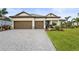 Beautiful single-story home with a well manicured lawn, paver driveway, and a two-car garage at 4820 Coastal Days Ln, Bradenton, FL 34211
