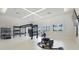 Well-equipped gym with specialized workout equipment and natural light from the windows at 4820 Coastal Days Ln, Bradenton, FL 34211