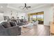 Open-concept living room with modern furnishings, large windows, and a view of the outdoor patio at 4820 Coastal Days Ln, Bradenton, FL 34211