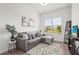 Cozy living room with a sectional, large window, modern decor, and wood flooring at 4820 Coastal Days Ln, Bradenton, FL 34211