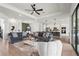 Spacious living area with comfortable sofas, tray ceiling, ceiling fan, and access to the kitchen at 4820 Coastal Days Ln, Bradenton, FL 34211