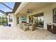 Covered outdoor patio with a dining area, grill, and TV, ideal for relaxation and entertainment at 4820 Coastal Days Ln, Bradenton, FL 34211