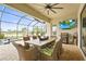 Screened-in outdoor patio with a dining area, grill, and TV, perfect for entertaining with lake views at 4820 Coastal Days Ln, Bradenton, FL 34211