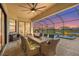 Covered and screened patio with an outdoor dining area, fan, and a relaxing pool with serene water views at 4820 Coastal Days Ln, Bradenton, FL 34211