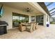 Outdoor covered patio with a large dining table, ceiling fan, outdoor kitchen and retractable screen at 4820 Coastal Days Ln, Bradenton, FL 34211