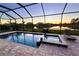 A screened-in pool and spa overlook the peaceful water view at sunset at 4820 Coastal Days Ln, Bradenton, FL 34211