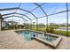 Screened-in pool area with a spa, lush landscaping, and serene water views creating a private oasis at 4820 Coastal Days Ln, Bradenton, FL 34211