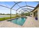 Sparkling pool and spa in a screened-in enclosure, surrounded by lush landscaping and views of the lake at 4820 Coastal Days Ln, Bradenton, FL 34211