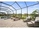 Relaxing screened-in pool area with brick pavers, lounge chairs and comfortable seating, overlooking a tranquil lake at 4820 Coastal Days Ln, Bradenton, FL 34211
