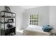 Cozy bedroom featuring a bed, shelf, and window with natural light at 5160 Northridge Rd # 206, Sarasota, FL 34238