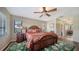 Cozy bedroom featuring a wooden bed frame, ceiling fan, and windows with blinds at 5630 Golf Pointe Dr # 205, Sarasota, FL 34243