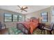 Comfortable bedroom with natural light, ceiling fan, and hardwood flooring with rug at 5630 Golf Pointe Dr # 205, Sarasota, FL 34243