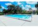 Refreshing community pool surrounded by manicured landscaping and trees, perfect for a relaxing swim at 5630 Golf Pointe Dr # 205, Sarasota, FL 34243