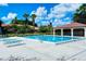 Community pool with lounge chairs and pool house, set in a picturesque landscaped area on a sunny day at 5630 Golf Pointe Dr # 205, Sarasota, FL 34243