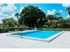 Community pool with lounge chairs surrounded by trees, offering a serene spot for relaxation at 5630 Golf Pointe Dr # 205, Sarasota, FL 34243