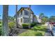 Two-story condo with neutral stucco, trimmed windows, mature landscaping, and dedicated parking at 5630 Golf Pointe Dr # 205, Sarasota, FL 34243