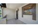 Front porch features a small outdoor light fixture, a welcome mat, and a window with blinds at 5630 Golf Pointe Dr # 205, Sarasota, FL 34243
