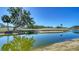 Scenic golf course view featuring a tranquil pond and lush green landscaping with a blue sky backdrop at 5630 Golf Pointe Dr # 205, Sarasota, FL 34243