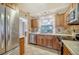 Well lit kitchen features stainless steel appliances, wood cabinetry and decorative tile backsplash at 5630 Golf Pointe Dr # 205, Sarasota, FL 34243