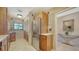 Bright kitchen featuring stainless steel refrigerator, wood cabinets, and pantry at 5630 Golf Pointe Dr # 205, Sarasota, FL 34243