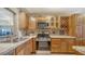 Open kitchen featuring wood cabinetry, stainless steel appliances, and tile backsplash at 5630 Golf Pointe Dr # 205, Sarasota, FL 34243