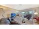 Spacious living room featuring plush seating, glass table, and access to outdoor balcony at 5630 Golf Pointe Dr # 205, Sarasota, FL 34243