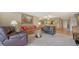 Spacious living room with neutral carpet, furnishings, and a view to the dining area at 5630 Golf Pointe Dr # 205, Sarasota, FL 34243