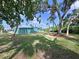 Large backyard features mature trees and the exterior of a light blue house at 5910 Majestic Way, Palmetto, FL 34221