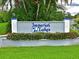 Close up of community sign for Imperial Lakes with blue lettering and manicured landscaping at 5910 Majestic Way, Palmetto, FL 34221