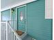 Close up of the front door on a house with teal siding and well maintained landscaping at 5910 Majestic Way, Palmetto, FL 34221