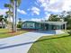 Charming home featuring a covered carport, well-manicured lawn, and vibrant landscaping at 5910 Majestic Way, Palmetto, FL 34221