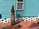 Artistic wood carving of a Personal with beard next to a blue sided home and brick foundation at 5910 Majestic Way, Palmetto, FL 34221