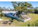 Aerial perspective of a home featuring a white fence, mature trees, and a well-maintained yard at 6387 Shalimar St, Port Charlotte, FL 33981