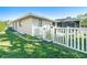 Exterior view of home with a white picket fence, grassy yard, and mature trees at 6387 Shalimar St, Port Charlotte, FL 33981